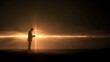 © slonme - A solitary figure in silhouette reads a book against a dramatic, glowing horizon, with light beams a