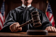 © lashkhidzetim - A judge is holding a gavel and standing in front of a flag