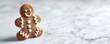 © shooreeq - An adorable, perfectly frosted gingerbread man cookie, sitting alone on a white marble countertop, ready to be decorated