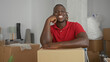 © Krakenimages.com - Man leaning on a cardboard box, hand on chin and arm resting across the box in a new home surrounded by moving boxes; fresh start contentment.