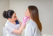 © Maria - Professional cosmetician examining face skin of girl in clinic of esthetic cosmetology
