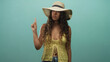 © Krakenimages.com - Woman points index finger wearing sunhat and yellow vest in studio, curly hair and denim jeans visible; assertive instruction.