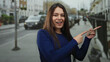 © Krakenimages.com - Woman excitedly pointing at something in an urban street setting with cars in the background, captured in daylight portraying joyful expression outdoors.