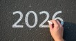 © Anil - Hand writing 2026 chalk on asphalt New Year planning.