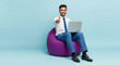 © Niks Ads - Happy Businessman Thumbs Up Working on Laptop on Bean Bag