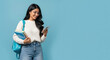 © Shivani - Happy Indian Student Using Smartphone with Books and Backpack