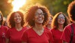 © Vadym - Group of women walk in solidarity outdoors wearing red tops smiling. Diverse females with curly hair support cause together in sunlight. Community unity togetherness celebration.