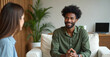 © Vadym - Black man smiling during therapy session with psychologist. He is in consultation receiving professional help. Mental health concept. Psychotherapy for depression treatment and support in office.