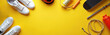 © Viktor - White sneakers, helmet, jump rope, skateboard, and water bottle are arranged on a bright yellow background. Various sport equipment laid out flat for training or exercise, ready for use.
