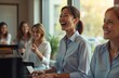 © Viktor - Diverse group of smiling women in an office enjoy singing while one plays piano. Colleagues share happy moments during a break, fostering team spirit and workplace joy.