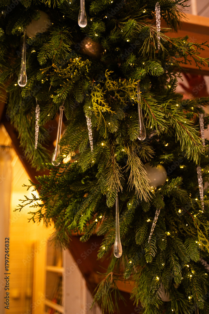 A Christmas tree branch on the stairs decorated with a garland and ...