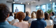 © perfectlab - Audience attentively listening to a speaker during a professional presentation in a modern conference room with natural light