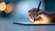 © perfectlab - Close-up of hand using digital pen on tablet with blurred background and warm lighting for creative digital drawing or writing