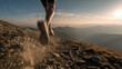 © Keopaserth - Trail runner descending rocky mountain trail at sunset with dust kicking up and distant ridgelines glowing in warm light