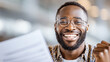 © venusvi - A cheerful man with glasses celebrates an achievement while holding a document with a joyful smile, showcasing success and happiness.