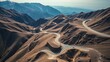 © XIN KONG - conductance. Aerial view of a winding mountain highway cutting through rugged terrain. travel magazines, destination branding, designed for outdoor magazines and nature guides.