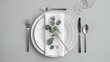 © AkuAku - Stylish table setting featuring cutlery, napkin, eucalyptus branch, and plate, ideal for editorial header background