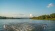 © TheWaterMeloonProjec - Scenic boat journey along a tranquil river with sky and nature in the backdrop
