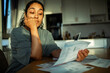 © Marko Geber - Young adult woman anxious about bills at home kitchen