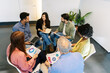 © Xavier Lorenzo - Business group sitting in circle discussing planning ideas. Coworkers reviewing charts in open workspace. Collaboration and planning concept.
