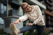 © Jelena - Smiling senior woman stretching leg for urban fitness
