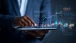 © CinimaticWorks - business analyst in a suit working on a tablet device featuring charts graphs and performance dashboards capturing financial insights strategic planning and data evaluation