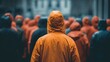 © Oleksandr - A person in an orange rain jacket stands out from a crowd of people wearing dark and orange jackets on a rainy day. The focus is on the individual amid collective experience.