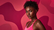 © Oleksandr - A confident dark-skinned model poses against a red backdrop. The model's flawless skin and perfectly styled short curly hair enhance the composition, and she's wearing a pink top.