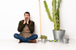 © luismolinero - Gardener man sitting on the floor at indoors shouting and announcing something