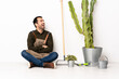 © luismolinero - Gardener man sitting on the floor at indoors happy and smiling