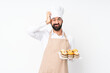 © luismolinero - Young man holding muffin cake over isolated white background with an expression of frustration and not understanding