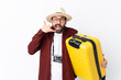 © luismolinero - Traveler man man with beard holding a suitcase over isolated white background making phone gesture and doubting
