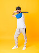 © luismolinero - Full-length shot of man over isolated yellow background playing baseball