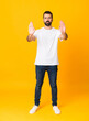 © luismolinero - Full-length shot of man with beard over isolated yellow background making stop gesture and disappointed