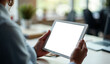 © Rhony - Close up of businesswoman holding tablet showing white screen on office desk