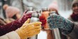 © MNStudio - Close-up of colorful thermoses clinked together by friends in knitted gloves, snow falling all around, smiles visible in soft focus. Winter warmth and joyful connection.