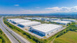 © MDNUR - Panoramic aerial view of a large industrial park with multiple warehouses and loading bays, showcasing logistics and distribution
