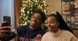 © ABCreative - Cheerful sister and brother unpack gifts and have video call with parents. They show decorated Christmas tree and living room and share their plans for the holidays.
