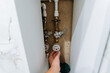 © Aleksey - plumber repairs water valve, skilled worker adjusting household shutoff valve properly, professional plumber carefully manipulating household shutoff valve for leak prevention and maintenance