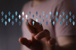© vegefox.com - Hand reaching towards a network of human icons, symbolizing connection, teamwork, and digital interaction in technology and business.