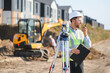 © Serhii - Surveyor communicating on construction site with theodolite