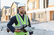 © Serhii - Surveyor man carrying surveying equipment at construction site