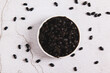© elenarui - Close up of fermented black douchi beans in a bowl on the table top view