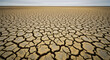 © GRAXO - Cracked earth in a dry landscape under a cloudy sky, showing the effects of drought.