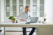 © Miljan Živković - Mature doctor working on laptop in medical office