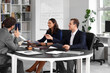 © Pixel-Shot - Team of lawyers working at table in office