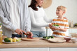 © Pixel-Shot - Little boy with his parents cooking Fajita in kitchen