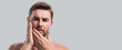 © Volodymyr - Sexy man close up portrait care of skin, isolated over gray background. Charming man with perfect smooth soft skin. Spa therapy. Man, face, beauty skincare concept. Banner for web header, copy space.