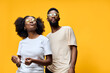 © SHOTPRIME STUDIO - Joyful young African couple in casual outfits, enjoying life against a vibrant yellow background, exuding confidence and happiness with stylish sunglasses