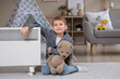 © Pixel-Shot - Cute little boy with toy bear and electric convector heater sitting at home